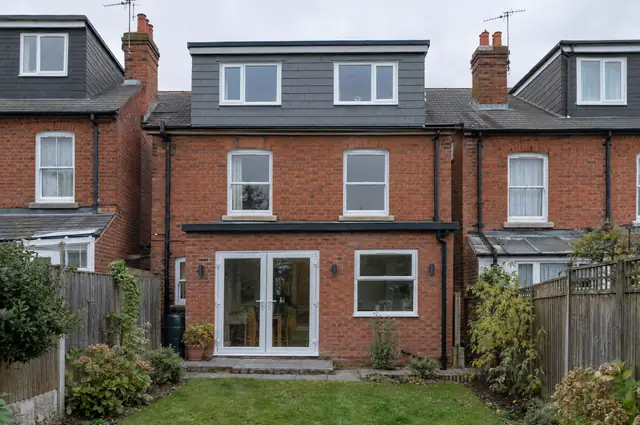 Full-width rear dormer loft conversion clad in grey tiles on a red-brick terraced house