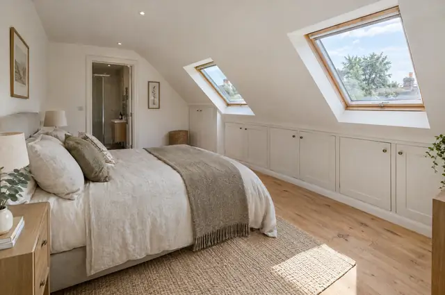 Finished loft bedroom with sloping ceilings, roof windows and built-in eaves storage